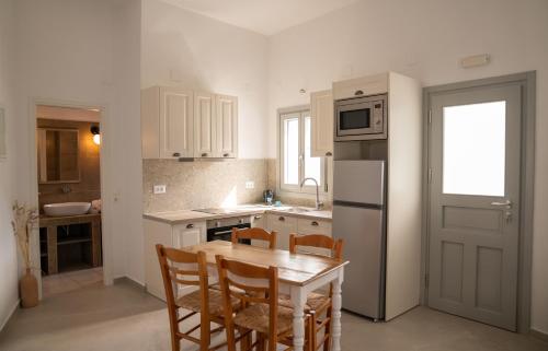 a kitchen with a table and chairs and a refrigerator at Ammos Sifnos Village in Platis Yialos Sifnos