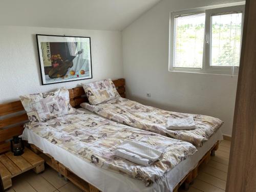 a bedroom with two beds and a picture on the wall at Villa Vesna in Veles