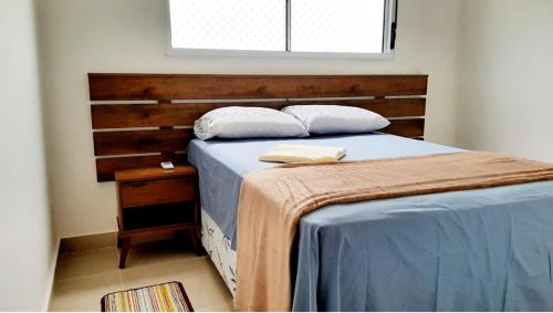 um quarto com uma cama e uma cabeceira em madeira em Apto novo Parque Mosaico em Manaus