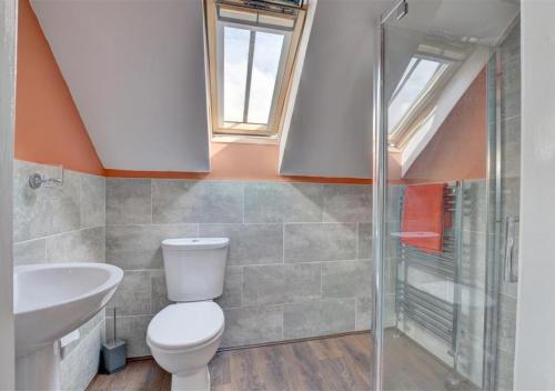 a bathroom with a toilet and a sink and a shower at The Old Cow Byre in Lealholm