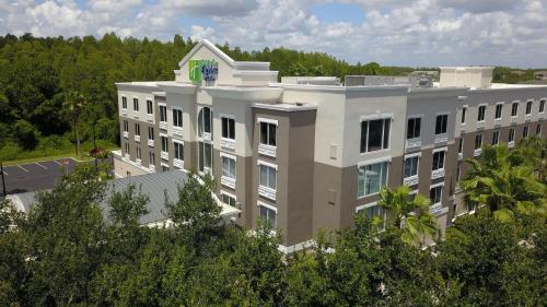 a large white building with trees in front of it at Holiday Inn Express and Suites Tampa I-75 at Bruce B. Downs by IHG in Tampa