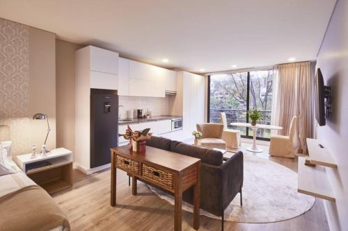a living room with a couch and a kitchen at 305 New Fancy Loft Parque El Virrey by LETOH in Bogotá