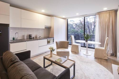 a living room with a couch and a kitchen at 305 New Fancy Loft Parque El Virrey by LETOH in Bogotá