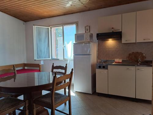 kuchnia ze stołem i białą lodówką w obiekcie Casa Solanas new w mieście Sìnnai
