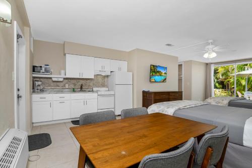 a room with two beds and a table and a kitchen at The Fairways Inn of Naples in Naples