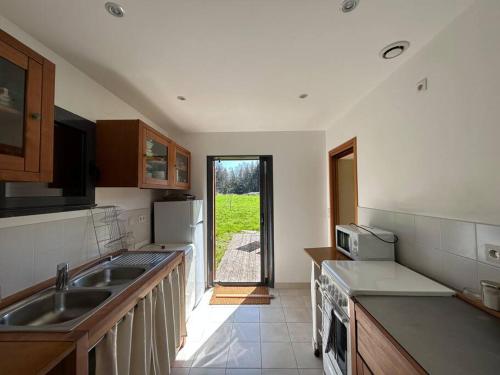 une cuisine avec un évier et un plan de travail dans l'établissement Maison de charme dans la nature, à Clohars-Fouesnant