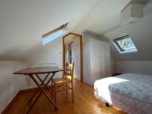 une chambre avec un lit, une table et une fenêtre dans l'établissement Maison de charme dans la nature, à Clohars-Fouesnant