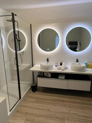 une salle de bain avec deux lavabos et deux miroirs dans l'établissement Superbe T5 2mn à pied de l'océan, à Anglet