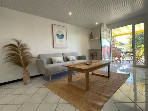 a living room with a couch and a table at JARDIN SUR MER in Terre-de-Haut