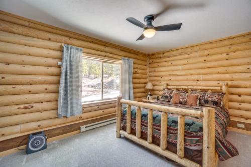 a log cabin bedroom with a bed and a ceiling fan at Mountain-View Front Range Colorado Vacation Rental in Red Feather Lakes