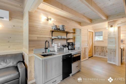 a kitchen in a log cabin with a sink at The Blackjack Oak in Treehouse Grove at Norton Creek in Gatlinburg