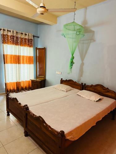 a bedroom with a large bed with a ceiling at Hotel Prasanna in Trincomalee