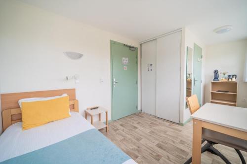 a bedroom with a bed and a desk and a table at Centre Jean XXIII in Annecy