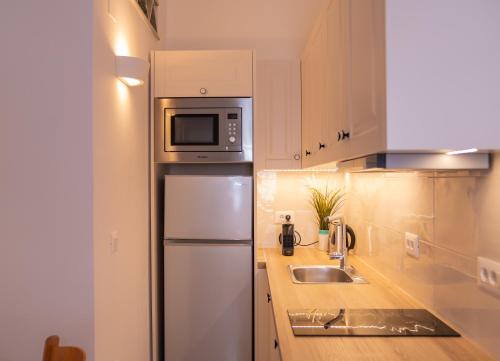 a kitchen with a refrigerator and a microwave at Ammos Sifnos Village in Platis Yialos Sifnos