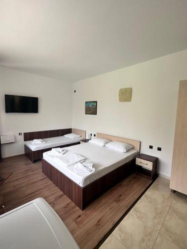 a bedroom with two beds and a flat screen tv at Paradox Oituz in Eforie Sud