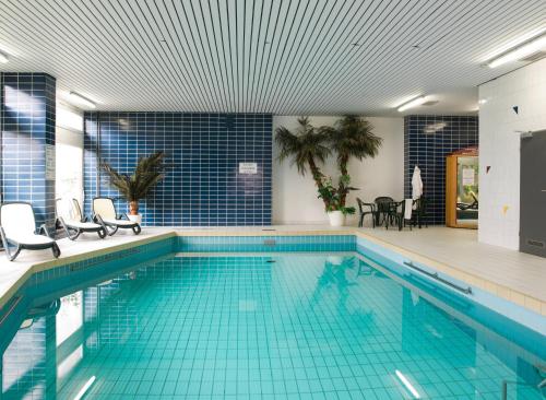 una gran piscina con suelo de baldosa azul en Haus Bayerwald en Neureichenau