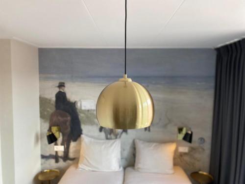 a bedroom with a bed with a painting of a horse at Hotel Steeds aan Zee in Katwijk