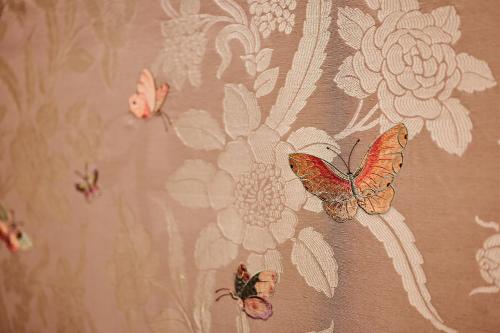a curtain with butterflies on it with flowers at Bernsteinschloss in Wendorf