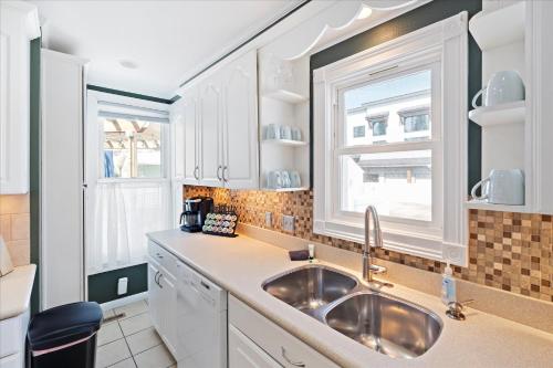 a kitchen with a sink and two windows at The Manse in Whitefish