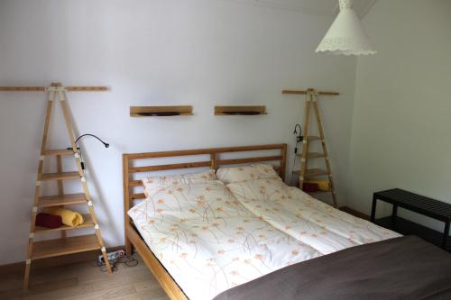 ein Schlafzimmer mit einem Bett mit zwei Regalen an der Wand in der Unterkunft A CÔTE in Môtiers