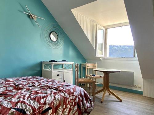 - une chambre avec un lit, une table et une fenêtre dans l'établissement L'appartement de la Place, à Saint-Valery-en-Caux