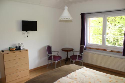 1 dormitorio con 1 cama, mesa y sillas en A CÔTE, en Môtiers