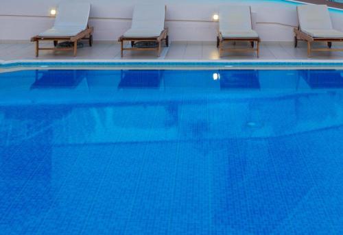 uma piscina com duas cadeiras e uma piscina em Aspasias Luxury Suite em Chania Town