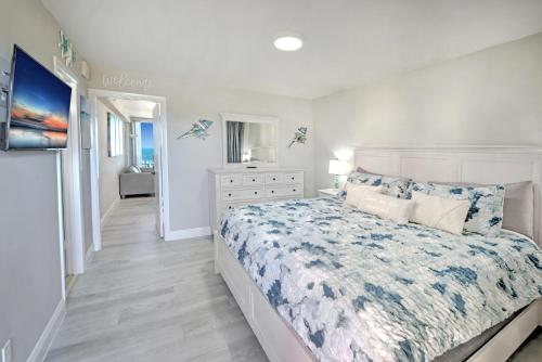 a white bedroom with a bed and a dresser at Harbour Beach Resort in Daytona Beach