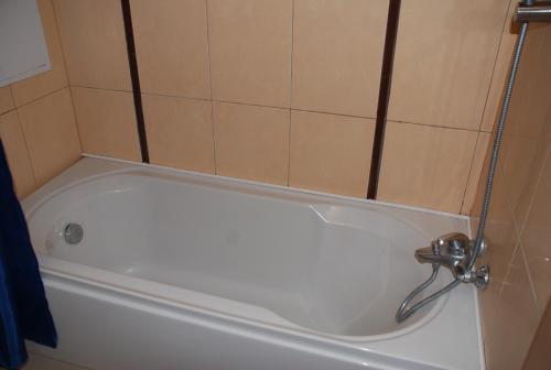 La salle de bains est pourvue d'une baignoire avec un robinet. dans l'établissement Marina Hotel Apartaments, à Pomorie