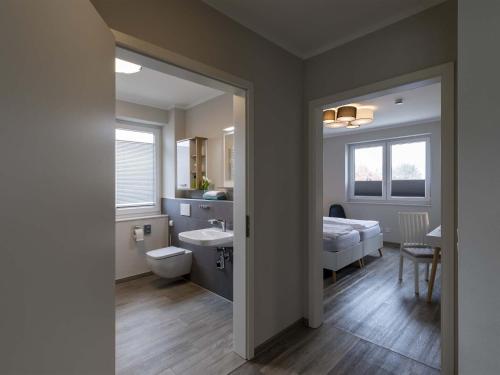 La salle de bains est pourvue d'un lavabo et d'un lit dans la chambre. dans l'établissement Exclusive apartment on Fehmarn, à Petersdorf auf Fehmarn