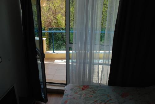 - une chambre avec une porte s'ouvrant sur un balcon dans l'établissement Marina Hotel Apartaments, à Pomorie