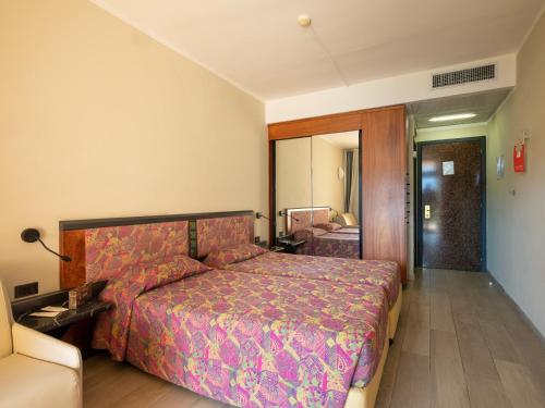 a bedroom with a bed and a room with a mirror at Hotel Leonardo Da Vinci in Limone sul Garda