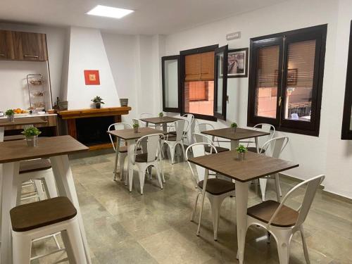 a restaurant with wooden tables and white chairs at Hotel Las Tablas in Daimiel