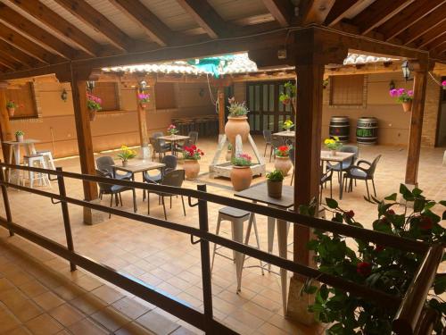 un patio al aire libre con mesas, sillas y macetas en Hotel Las Tablas en Daimiel