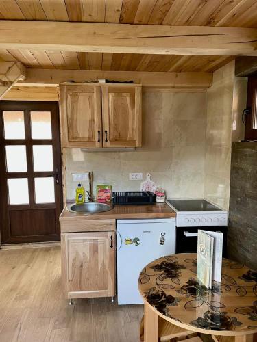 a kitchen with a stove and a sink and a table at brvnare in in Sekulić 
