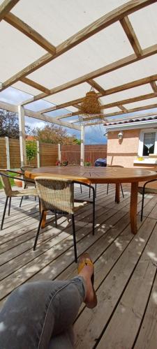 une personne sur une terrasse avec une table et des chaises dans l'établissement Chez Isa et JP, à Soulac-sur-Mer