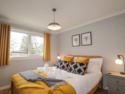 a bedroom with a bed and a window at Pebble Cottage in Portree
