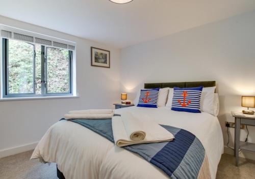 a bedroom with a large bed with blue pillows at Zephyr in Fowey