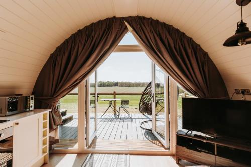 a living room with a large window and a patio at Gopsall Hall Farm in Atherstone