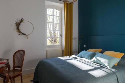 - une chambre bleue avec un lit, une table et une fenêtre dans l'établissement Grand gîte avec piscine MAISON PORT VALADE, à Tabanac