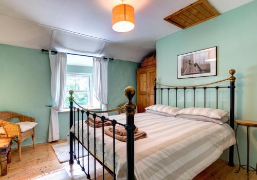a bedroom with a large bed and a window at Woodbine Cottage in Saint Hilary
