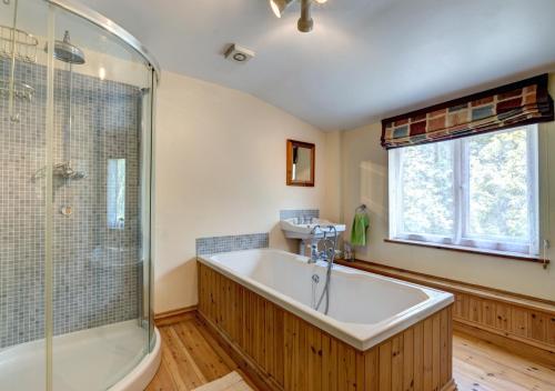 a bathroom with a large tub and a shower at Woodbine Cottage in Saint Hilary