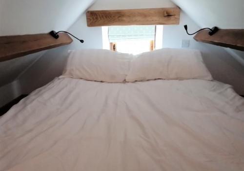 ein weißes Bett in einem Zimmer mit Fenster in der Unterkunft The Hayloft in Nawton