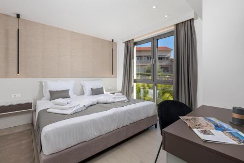 a bedroom with a bed and a desk and a window at HADRIE LUXURY RESORT AND VILLAS Krk in Krk