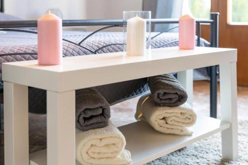 stół z 2 świecami i ręcznikami na łóżku w obiekcie Elite Home w mieście Monfalcone