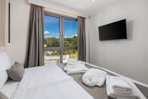 a bedroom with a bed with white towels on it at HADRIE LUXURY RESORT AND VILLAS Krk in Krk