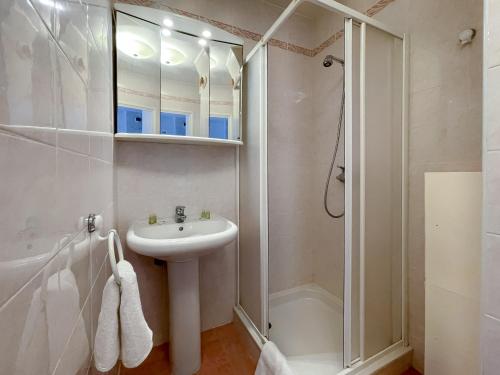 a white bathroom with a sink and a shower at Les Terrasses 2Pers Parking WiFi in Roquebrune-Cap-Martin