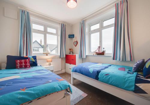 a bedroom with two beds and two windows at The Haggs in Sandsend