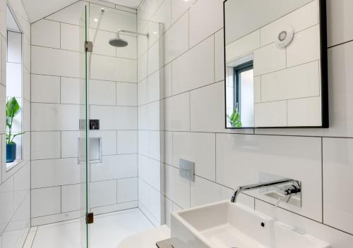 W białej łazience znajduje się umywalka i lustro. w obiekcie The Granary at The Foldyard w mieście Holme upon Spalding Moor