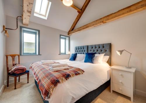 a bedroom with a large white bed with blue pillows at The Granary at The Foldyard in Holme upon Spalding Moor